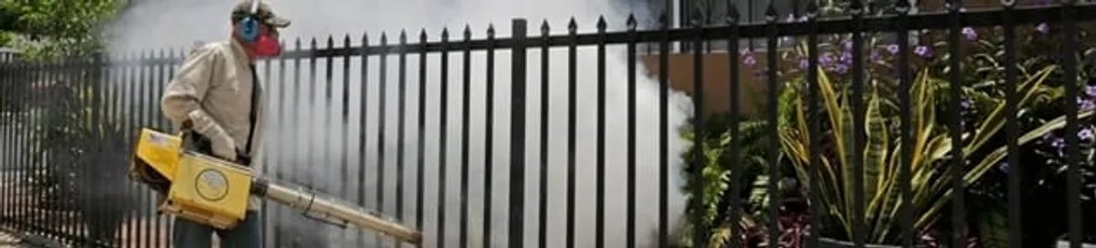 Mosquito control technician fogging a yard perimeter for mosquito reduction in Chicago, IL